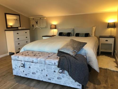a bedroom with a large white bed with a ottoman at Beynon&Bolton’s Country Loft Escape in Katikati