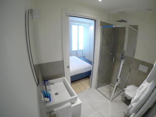 een badkamer met een douche, een wastafel en een toilet bij La Casa sul Lago Lecco in Lecco