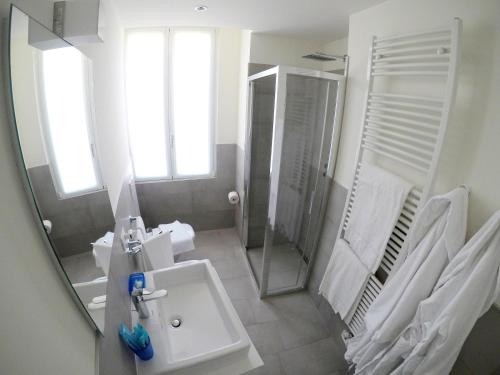 a bathroom with a sink and a shower and a mirror at La Casa sul Lago Lecco in Lecco