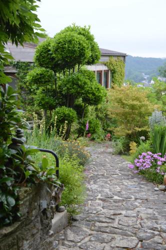 a stone path in front of a house with flowers at Jardin de Belle Vue in Quimperlé