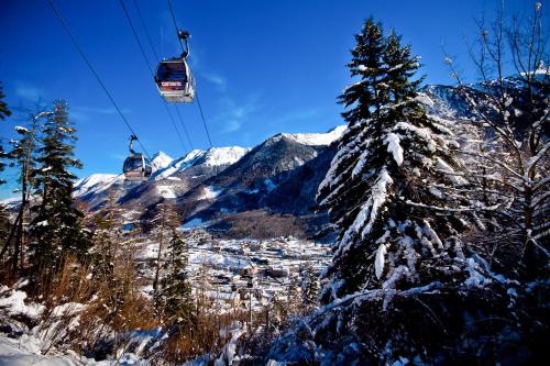 a ski lift in the mountains with snow covered trees at Appartement rénové & calme - Centre-ville 4 à 6 Pers - 2eme Étage Cuisine Équipée- Linge et Ménage en option in Cauterets