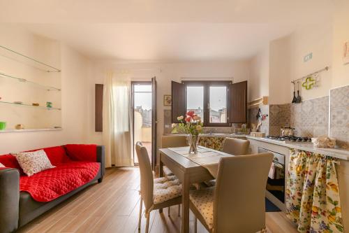 eine Küche und ein Wohnzimmer mit einem Tisch und einem Sofa in der Unterkunft Le casette di nonno Pippo in Palazzolo Acreide