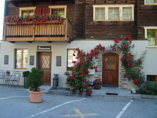 a building with flowers on the side of it at Hotel Restaurant Alpenblick in Ernen