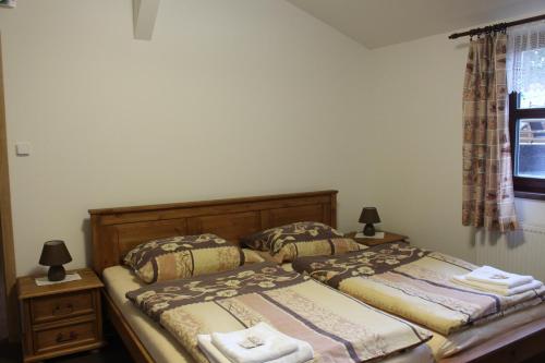 two beds in a bedroom with two lamps and a window at Relax pension Schonwald in Budišov nad Budišovkou