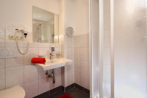 a white bathroom with a sink and a shower at Landhaus Fiegl in Sölden