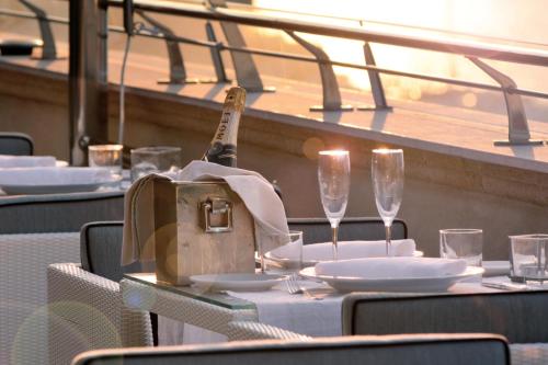 a table with a bottle of wine and glasses on it at Palazzo del Corso – Boutique Hotel in Gallipoli