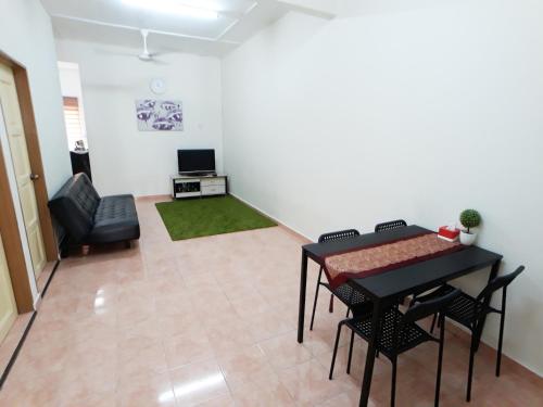 a living room with a table and a chair at JJ Melaka Holiday home in Melaka