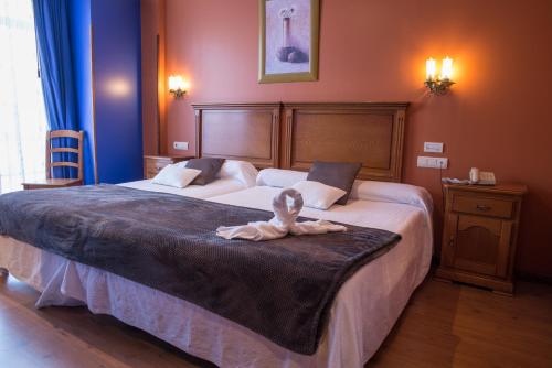 a bedroom with a large bed with a towel on it at Hotel Marfrei in Hinojedo