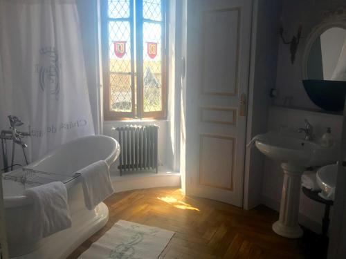 La salle de bains est pourvue d'une baignoire, d'un lavabo et d'une fenêtre. dans l'établissement Château de Varennes, à Varennes-lès-Mâcon