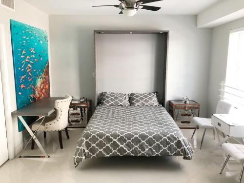 a bedroom with a bed and a desk and a ceiling fan at Heart of South Beach / Modern Apartment / Ocean Drive - Carlyle in Miami Beach