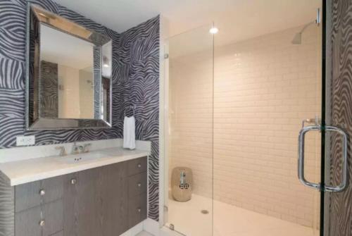 a bathroom with a sink and a glass shower at Heart of South Beach / Modern Apartment / Ocean Drive - Carlyle in Miami Beach