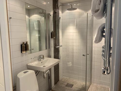 a white bathroom with a sink and a shower at Näsby Slott in Täby