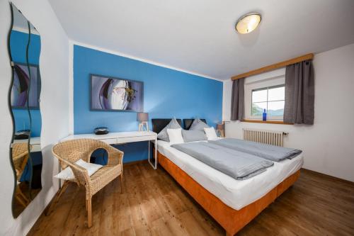1 dormitorio con cama, escritorio y ventana en Alpinplus, en Zöblen