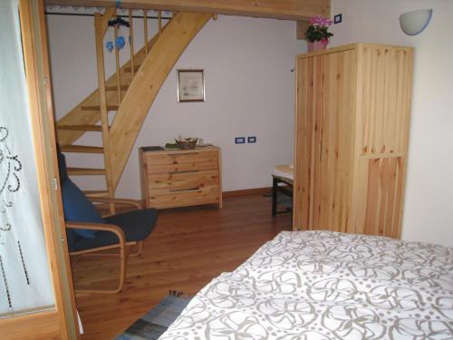 een slaapkamer met een bed en een houten trap bij B&B Anna Maria in Ledro