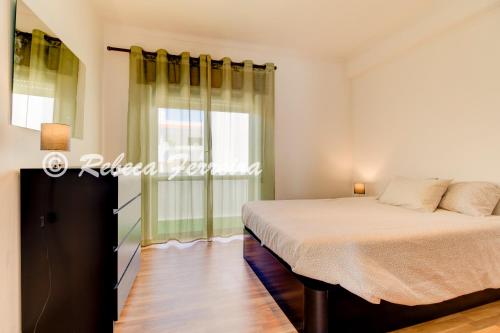 Schlafzimmer mit einem Bett und einem Fenster in der Unterkunft Villas2go2 T1 Miramar in Carvoeiro