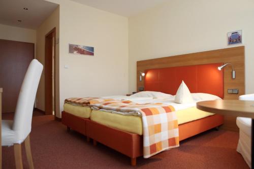 a hotel room with a bed and a table at Hotel Garni Max Zwo in Dingolfing