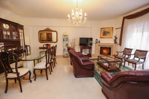 a living room with a table and chairs and a chandelier at Like-home-T4-Bright Benfica Apt-Terrace in Lisbon