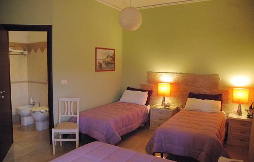 una camera d'albergo con due letti e un bagno di A Casa Olimpia B&B a Giarre