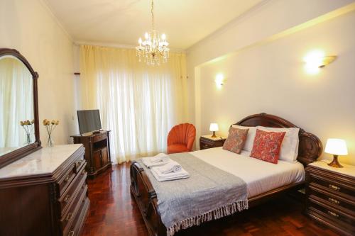 Un dormitorio con una cama, una cómoda y un espejo. en Like-home-T4-Bright Benfica Apt-Terrace, en Lisboa