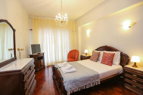 - une chambre avec un lit, une commode et un miroir dans l'établissement Like-home Bright Benfica Apt, à Lisbonne