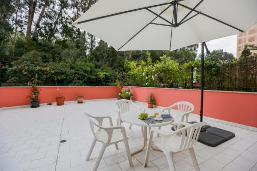 a patio with a white table and chairs and an umbrella at Like-home-T4-Bright Benfica Apt-Terrace in Lisbon