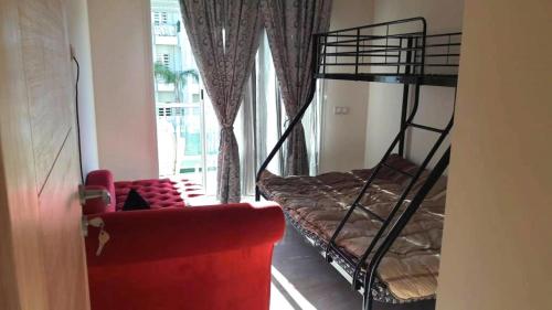 a living room with a red couch and a bunk bed at F3 Casabay beach sidi rahal vue sur piscine in Sidi Rahal