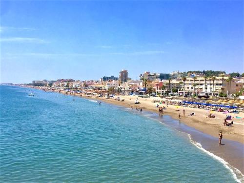 a beach with a bunch of people on it at Hotel Cabello in Torremolinos