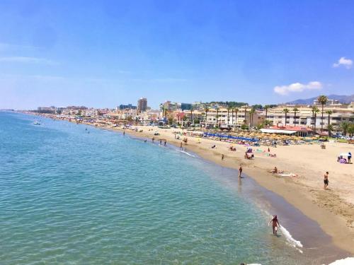 a beach with a bunch of people in the water at Hotel Cabello in Torremolinos