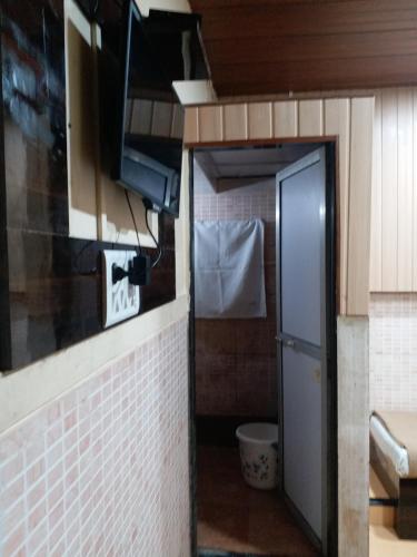 a small bathroom with a toilet and a door at Hotel Regal Plaza in Mumbai