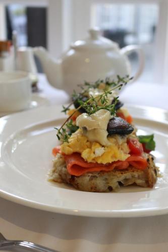 a white plate with a breakfast sandwich on a table at The Devon Valley Hotel in Stellenbosch
