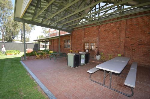 a patio with a picnic table and a bench at Tasman Holiday Parks - Merool on the Murray in Echuca