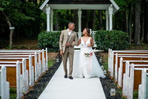 a bride and groom walking down a aisle at Georgia Palms & Gardens in Powder Springs