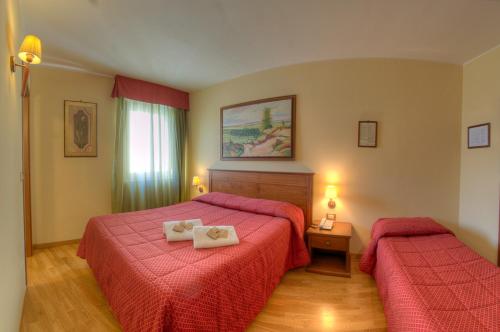 Habitación de hotel con 2 camas con sábanas rojas en Hotel Garnì Posta, en Pescasseroli