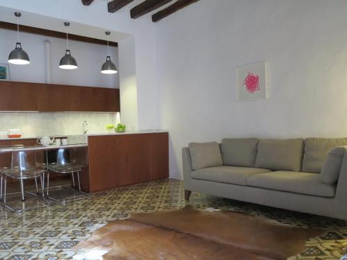 a living room with a couch and a kitchen at Heart of Pollensa in Pollença