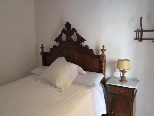 a bedroom with a bed with a wooden headboard and a table at Heart of Pollensa in Pollença