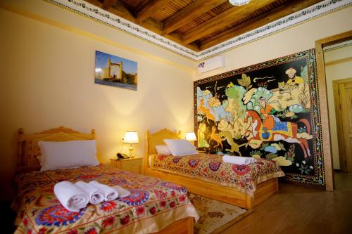 a bedroom with two beds and a painting on the wall at Basilic Boutique Hotel in Bukhara