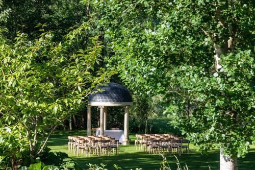 a gazebo with a bunch of tables and chairs at Old Swan & Minster Mill in Minster Lovell