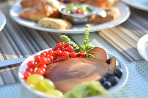 a bowl of fruit on a table with other plates of food at Palazzo del Corso – Boutique Hotel in Gallipoli