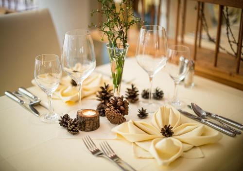 a table with wine glasses and decorations on it at Natur Pur Hotel Unterpichl in Ultimo