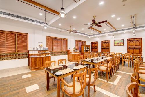 a dining room with wooden tables and chairs at Sterling Guruvayur in Guruvāyūr