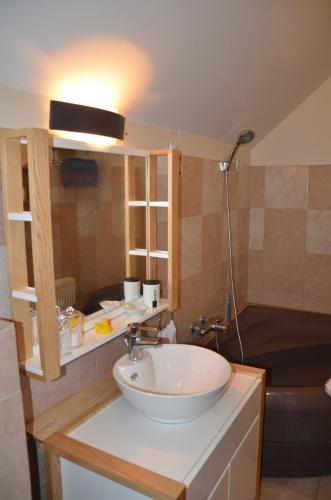 a bathroom with a sink and a toilet and a tub at Le Gîte de la Gentilhommière du Château de Ragnies. in Lyrée