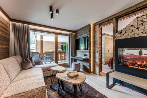 a living room with a couch and a fireplace at BAD MOOS - Aqua Spa Resort in Sesto