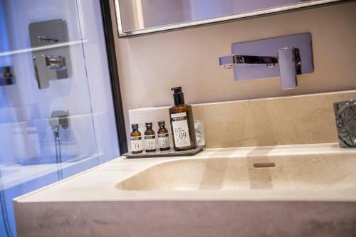 a bathroom sink with bottles of alcohol on it at BAD MOOS - Aqua Spa Resort in Sesto