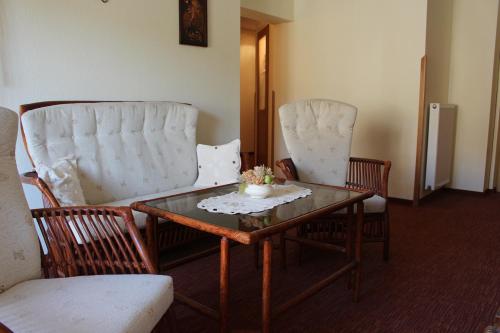 a room with two chairs and a table with a coffee table at Pension Zur Grünen Eiche in Kaulsdorf