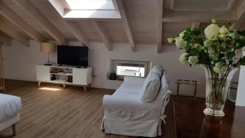salon z kanapą i wazą kwiatów w obiekcie DE PIANTE GUEST w mieście Busto Arsizio