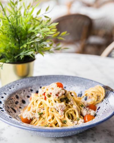 a plate of pasta with meat and vegetables on a table at The Swan, Streatley, Berkshire in Streatley