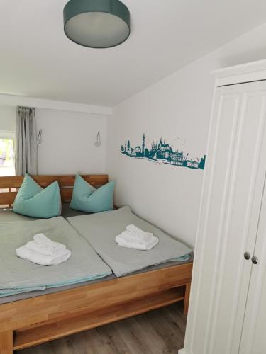 a bedroom with a bed with blue pillows at Gästehaus Twee Linden in Warnemünde