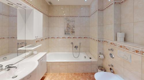 a bathroom with a bath tub and a sink at Aurora Apartments in Bad Homburg vor der Höhe