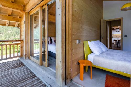 a bedroom in a tiny house with a bed and a balcony at Superbe chalet-11 personnes-Chamonix(Les Bossons) in Chamonix-Mont-Blanc