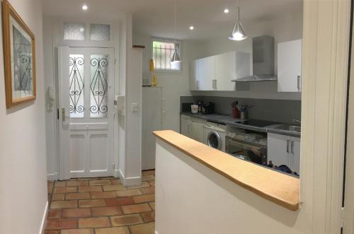 une cuisine avec des armoires blanches et un comptoir dans l'établissement Nice Grand appartement face jardin, à Nice